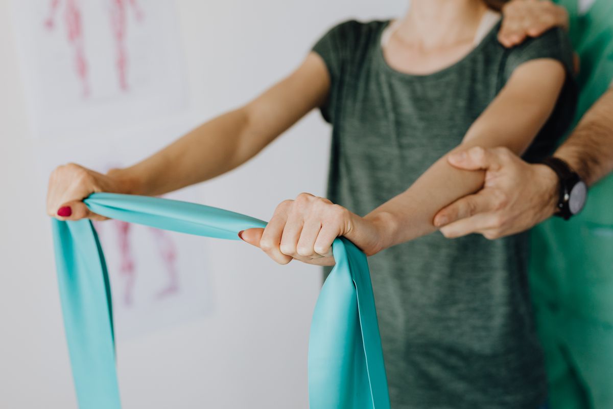 Resistance band shoulder exercise coached in the clinic